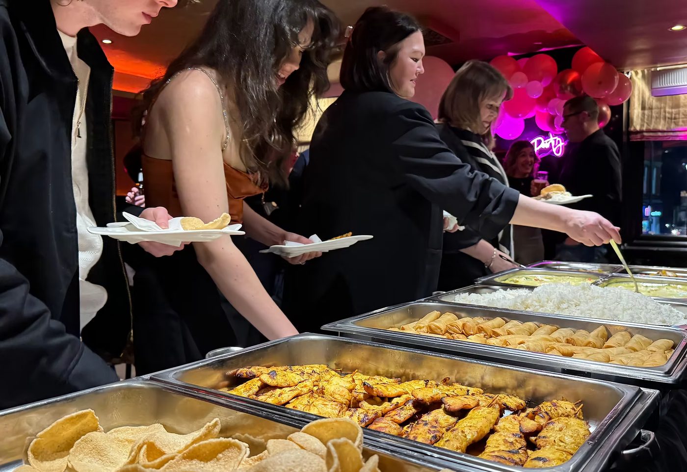 Guests serving themselves from a Thai buffet in the private dining room at Tom Yam