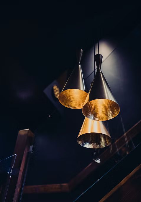 Brass pendant lights above the tables in the dining room